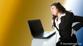 a person Juneau bending over a computer holding her back due to pain